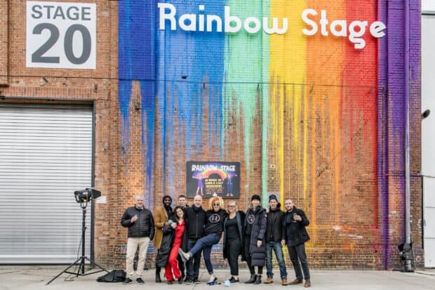 A group of people stands in front of the Rainbow Stage mural honoring Lana Wachowski, 2K Desktop Wallpaper