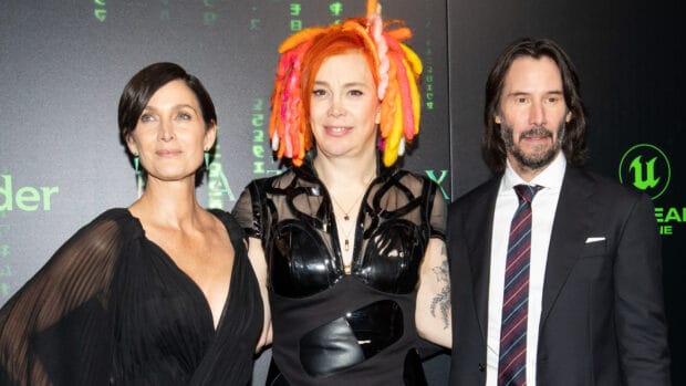 Lana Wachowski stands between two film stars wearing formal attire, HD Desktop Wallpaper