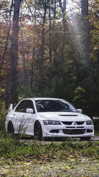 A white Lancer Evo is parked in a forest surrounded by autumn trees and fallen leaves, HD Mobile Wallpaper