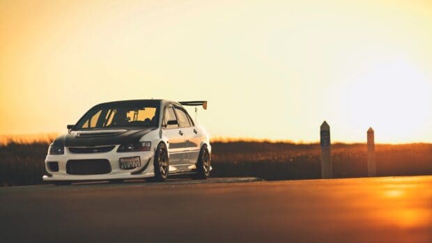 A white and black Lancer Evo parked on the road during sunset with a golden sky, HD Desktop Wallpaper