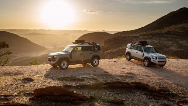 Two Land Rover Defender vehicles parked near rocky hills at sunset, 4K Desktop Wallpaper