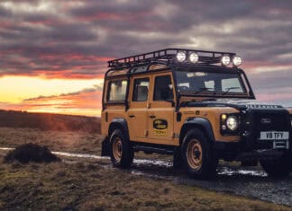 A Land Rover Defender is parked on a muddy track at sunset in a rural setting, 4K Desktop Wallpaper