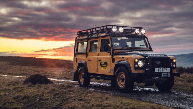A Land Rover Defender is parked on a muddy track at sunset in a rural setting, 4K Desktop Wallpaper