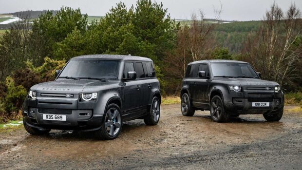 Two Land Rover Defender vehicles parked on a muddy trail in a forested area, HD Desktop Wallpaper