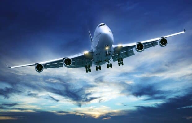 A large commercial aircraft is flying through dramatic clouds during sunset, HD Desktop Wallpaper