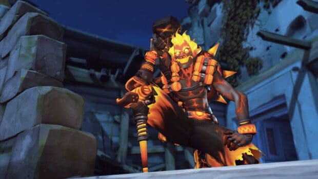 The Junkrat character with fiery glowing features is crouching near stone ruins, 4K PC Wallpaper