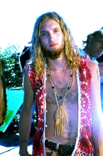 Layne Staley wallpapers showing a young man with long hair and necklaces in an outdoor setting, 2K Mobile Wallpaper