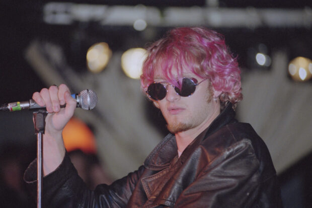 A close up of Layne Staley holding a microphone on stage wearing a leather jacket, HD Desktop Wallpaper
