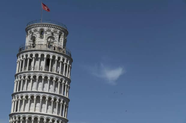 The Tower of Pisa stands prominently with a flag against a clear blue sky, 2K Desktop Wallpaper