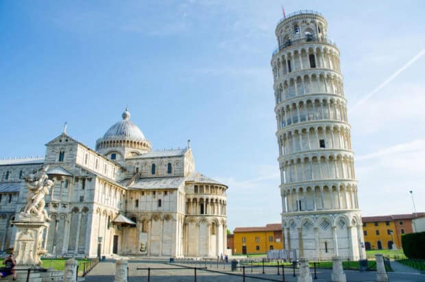 The Tower of Pisa stands beside historic buildings under a clear blue sky in this photo, 2K Desktop Wallpaper