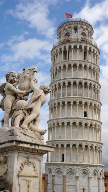 The Tower of Pisa stands next to a detailed statue under a cloudy sky, HD Phone Wallpaper