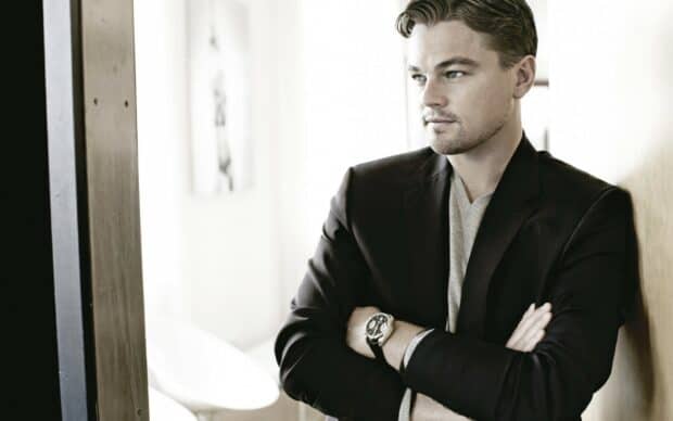 Leonardo Dicaprio is standing with arms crossed wearing a black blazer and looking to the side, HD Desktop Wallpaper