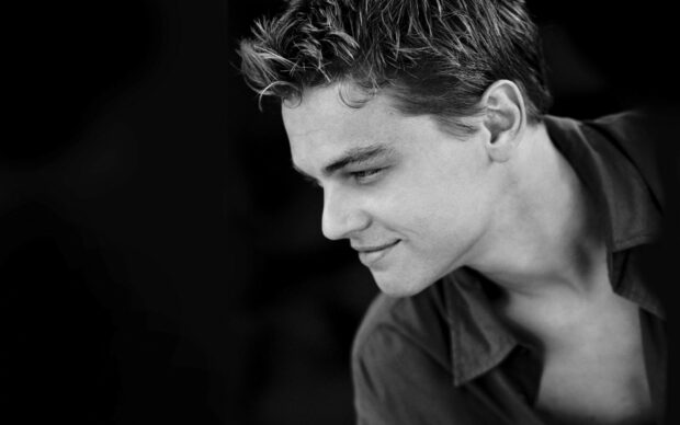 Leonardo Dicaprio is looking down with a slight smile in this black and white portrait, HD Desktop Wallpaper