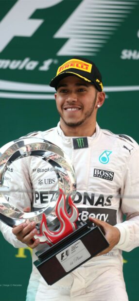 Lewis Hamilton smiles holding his racing trophy after winning a Formula 1 race, HD Phone Wallpaper
