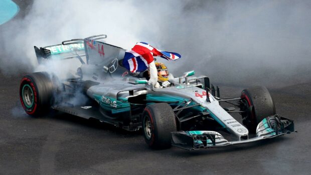 Lewis Hamilton drives a Formula 1 car with a British flag during his victory celebration, HD Desktop Wallpaper