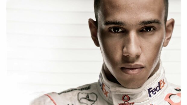 A close up portrait of Lewis Hamilton wearing his racing suit with sponsor logos, 4K Desktop Wallpaper