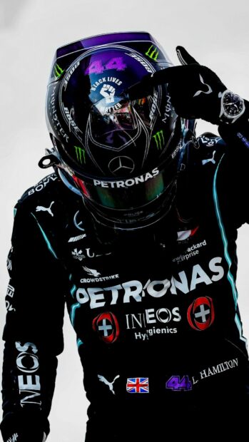 Lewis Hamilton wears his racing suit and helmet while posing with a clenched fist, HD Mobile Wallpaper