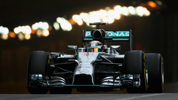 Lewis Hamilton drives a Formula 1 car in a night race with bright lights, 4K Desktop Wallpaper
