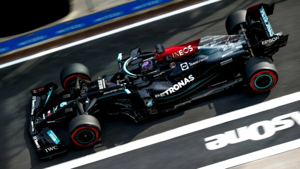 Lewis Hamilton is driving a Mercedes AMG F1 car at high speed, 2K Desktop Wallpaper