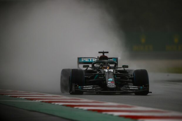 Lewis Hamilton races his Formula 1 car on a wet track creating spray behind, 2K Desktop Wallpaper
