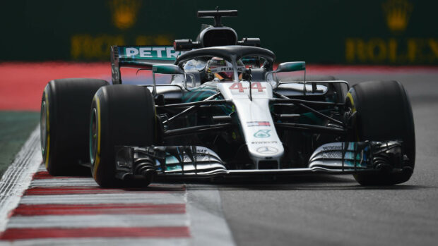 Lewis Hamilton races a Mercedes F1 car at high speed on a race circuit, 2K Desktop Wallpaper