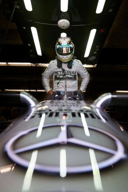 Lewis Hamilton stands behind his Mercedes race car in the garage, HD Desktop Wallpaper