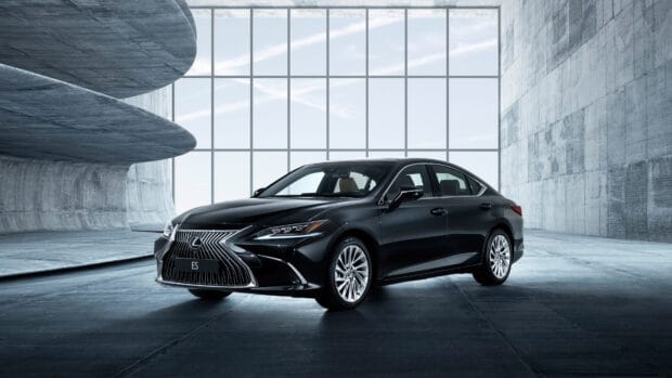 A black Lexus ES sedan is parked inside a modern concrete building with large windows, 4K Desktop Wallpaper