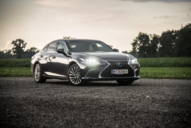 A Lexus Es is parked outdoors on a gravel surface near a green field, HD Desktop Wallpaper