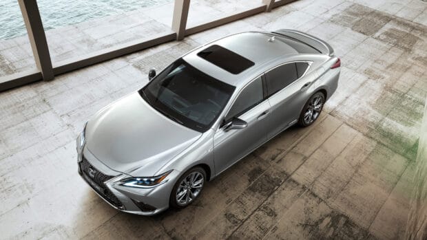A silver Lexus Es sedan parked near a waterfront with modern concrete surroundings, 4K Desktop Wallpaper