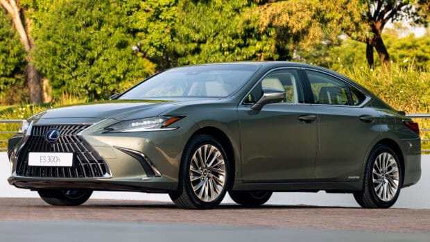 A green Lexus Es hybrid sedan parked outdoors with trees in the background, HD Desktop Wallpaper