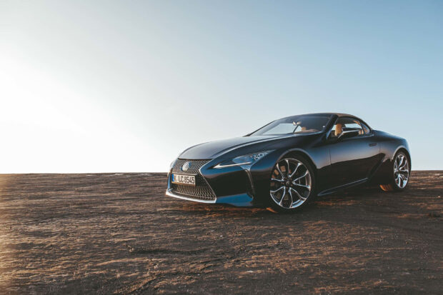 A black Lexus LC is parked on a rocky desert landscape under a clear sky, 2K Desktop Wallpaper