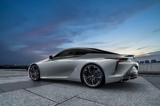 A silver Lexus LC is parked on a tiled surface under a cloudy evening sky, HD Desktop Wallpaper