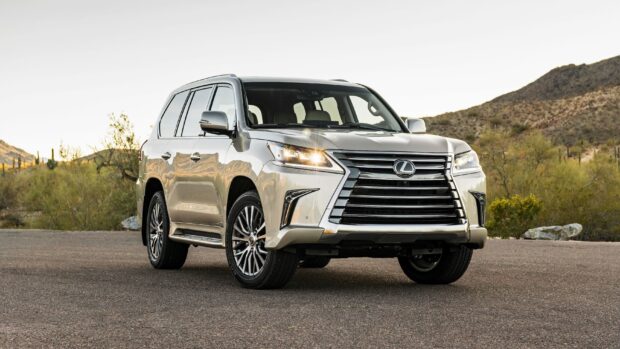 A Lexus LX SUV is parked on an asphalt road with desert hills in the background, 2K Desktop Wallpaper