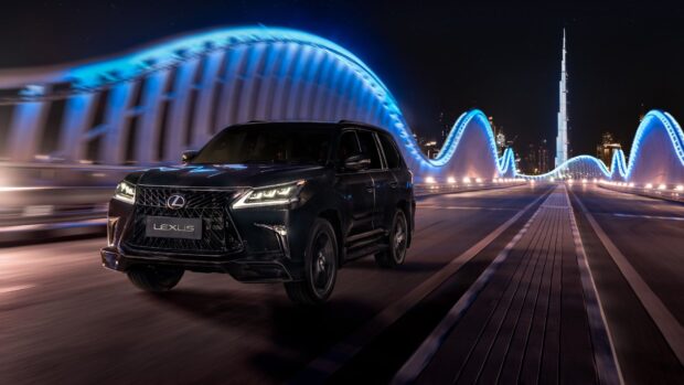 A Lexus LX is driving on a futuristic lit bridge at night with a city skyline in the background, HD Desktop Wallpaper