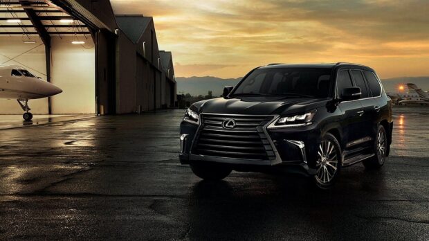 A black Lexus LX is parked near an aircraft hangar at sunset, showcasing sleek design, HD Desktop Wallpaper