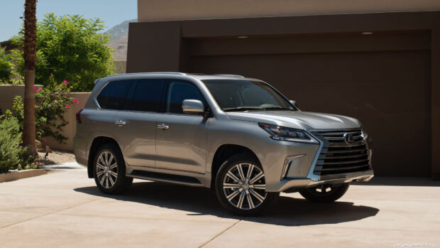A silver Lexus LX SUV is parked in front of a modern garage under sunlight, 4K Desktop Wallpaper