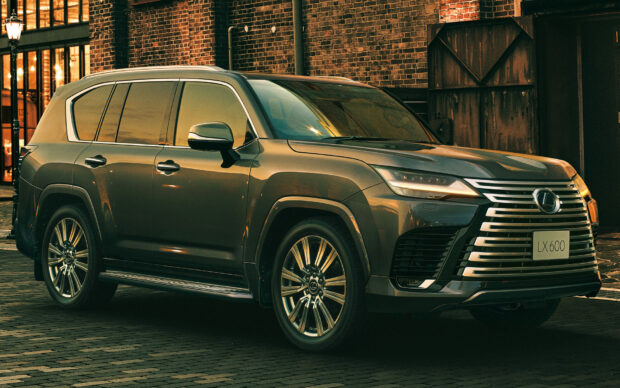 A Lexus LX model is parked on a brick street near industrial buildings during sunset, HD Desktop Wallpaper