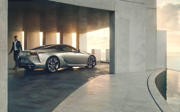 A Lexus Lc is parked near a modern concrete building with a man walking beside it, HD Desktop Wallpaper