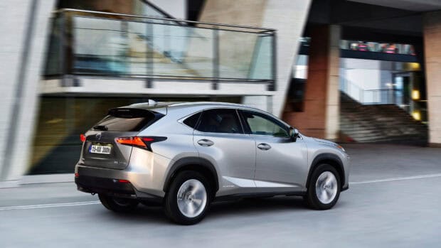 A silver Lexus NX 300h is driving through a modern city area with glass architecture, 4K Desktop Wallpaper