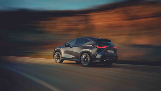 A Lexus Nx swiftly drives on a scenic road with blurred background showing speed, HD Desktop Wallpaper