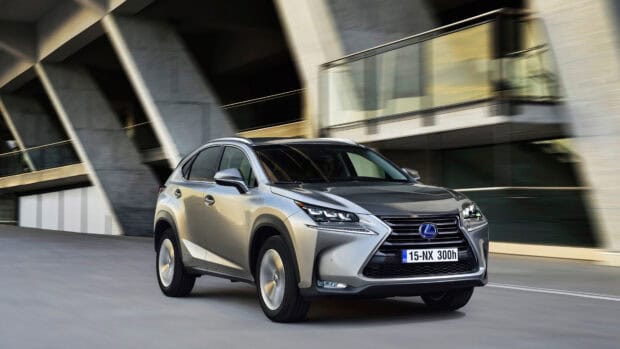 A Lexus Nx drives quickly past a modern building with architectural concrete beams, 4K Desktop Wallpaper