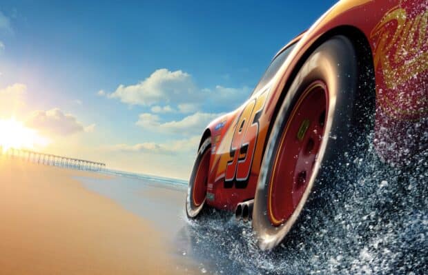 Lightning McQueen is driving swiftly along the beach with water splashing around, HD Desktop Wallpaper