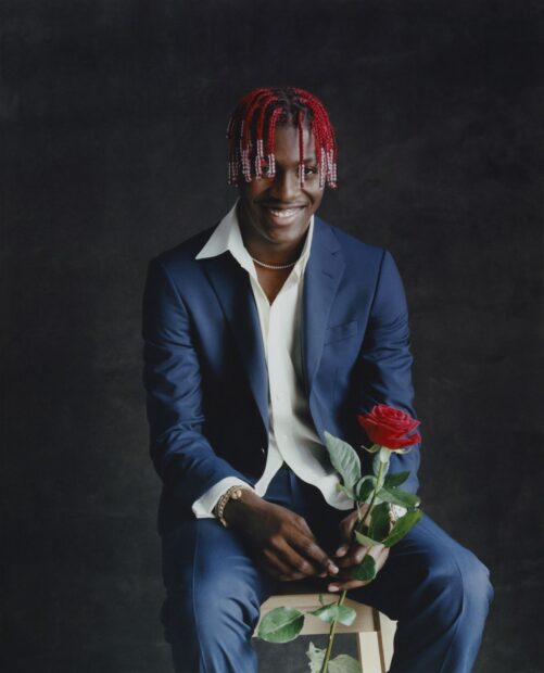 Lil Yachty holding a red rose seated in a blue suit smiling at the camera, HD Mobile Wallpaper