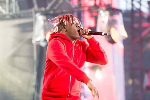 Lil Yachty performing live in a red hoodie holding a microphone during a concert, 2K Desktop Wallpaper