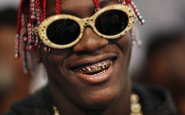 Lil Yachty wears gold grills and sunglasses with red beaded hair in this close up, 2K Desktop Wallpaper