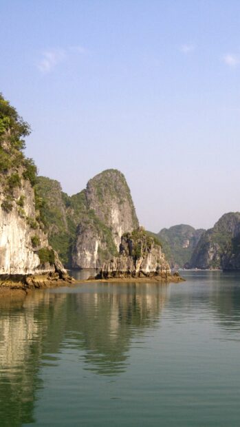 Vietnam Wallpapers show limestone islands and calm water under a clear sky, 2K Mobile Wallpaper