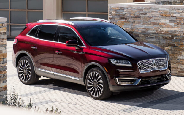A red Lincoln Nautilus SUV parked by stone walls under clear daylight, HD Desktop Wallpaper