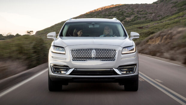 A white Lincoln Nautilus with two people inside drives along a winding road, 4K Desktop Wallpaper