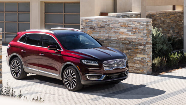 A red Lincoln Nautilus is parked outside a contemporary home with stone walls and driveway, 4K Desktop Wallpaper