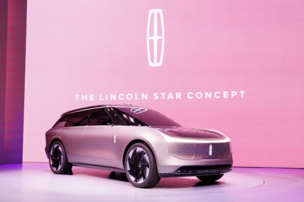 The Lincoln Star Concept is displayed in a modern showroom with a pink backdrop, showcasing futuristic design, 2K Desktop Wallpaper